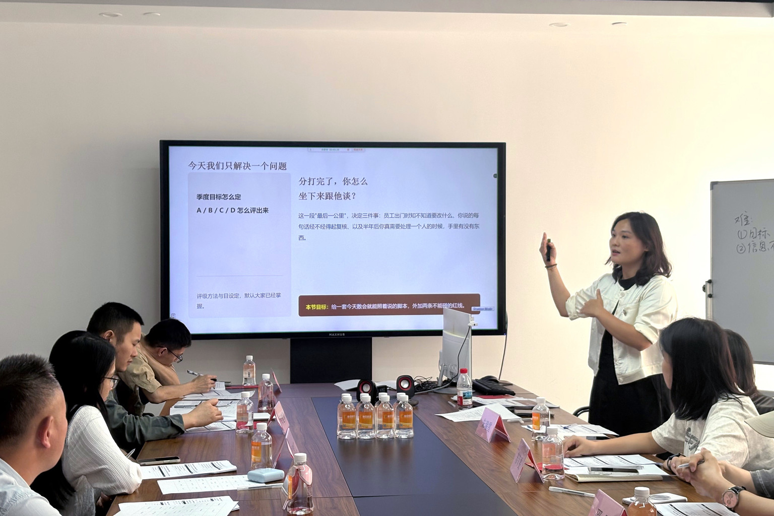 Trainer explaining a slide to participants around a meeting table